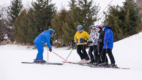 Group of skiers with instructor during beginner lesson at Blue Mountain