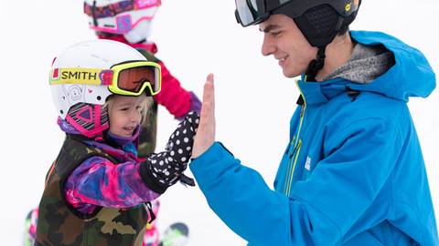 Small child with instructor at Tiny Tot Private Snowboard Lesson at Blue Mountain