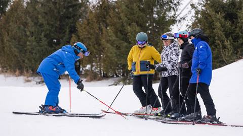 A group of people standing on skis on a snowy slope.