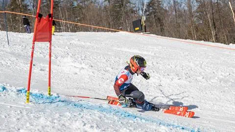 skier racing down a ski hill at blue mountain resort located on the ski school webpage