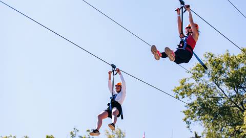 Two People riding the Blue Mountain Zip Line