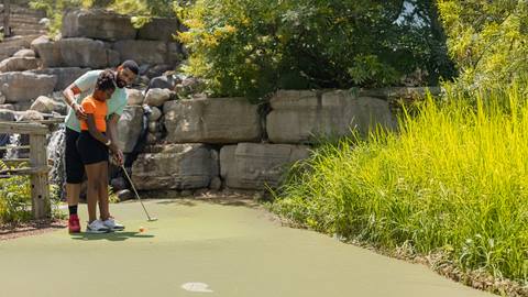a father and daughter playing at Cascade Putting Course