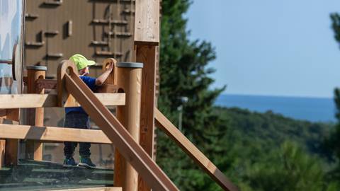 a child viewing the mountain landscape from the chutes and loops ball run kids play area in blue mountain