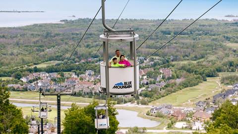 Parents and son riding the Open Air Gondola in the Summer at Blue Mountain