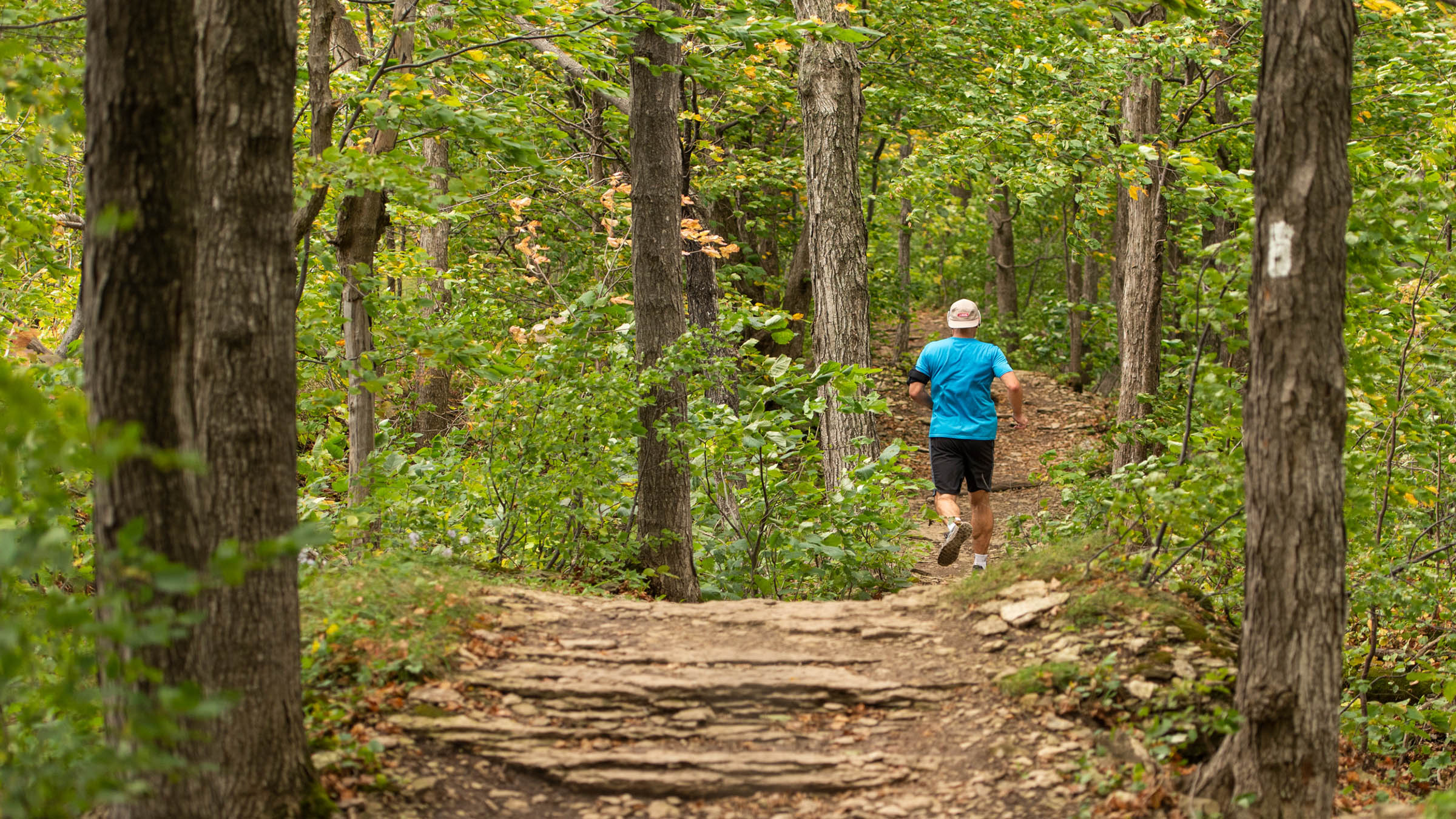 Man trail running along hiking trail in Blue Mountain Explore Park
