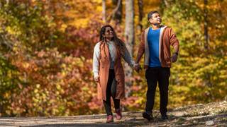 Couple holding hands and hiking through trails of Blue Mountain during Fall