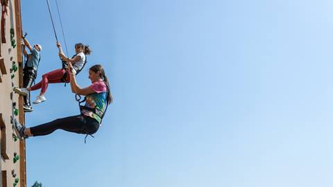 climbers rappelling down the side of the wooden climbing wall structure at blue mountain resort