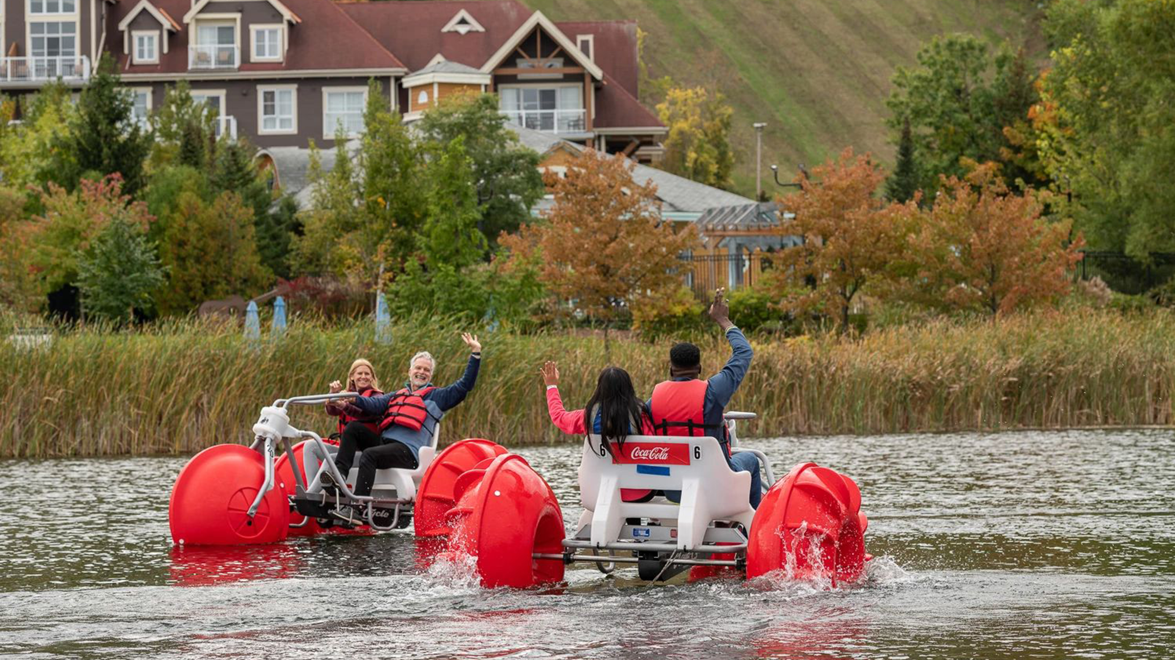 Couples waving to each other on water bikes in Blue Mountain Mill Pond in Fall