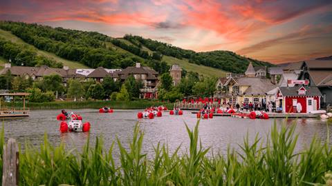 People riding on paddle boats on the Mill Pond at Blue Mountain during the sunset