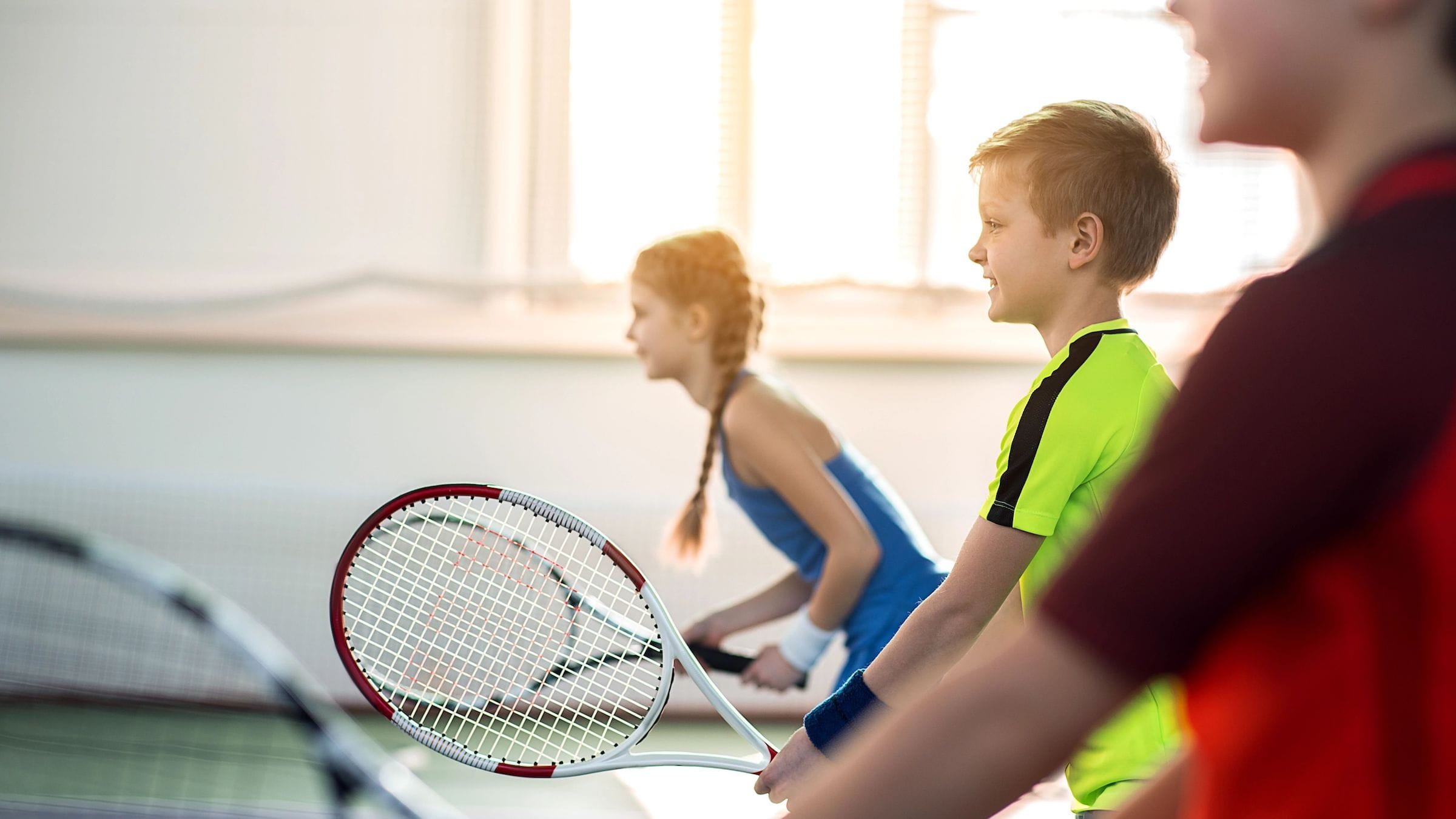 Group of youth with tennis rackets on court