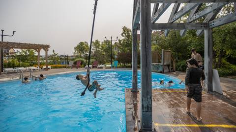 Person swinging on rope into Plunge! Swimming Pool at Blue Mountain