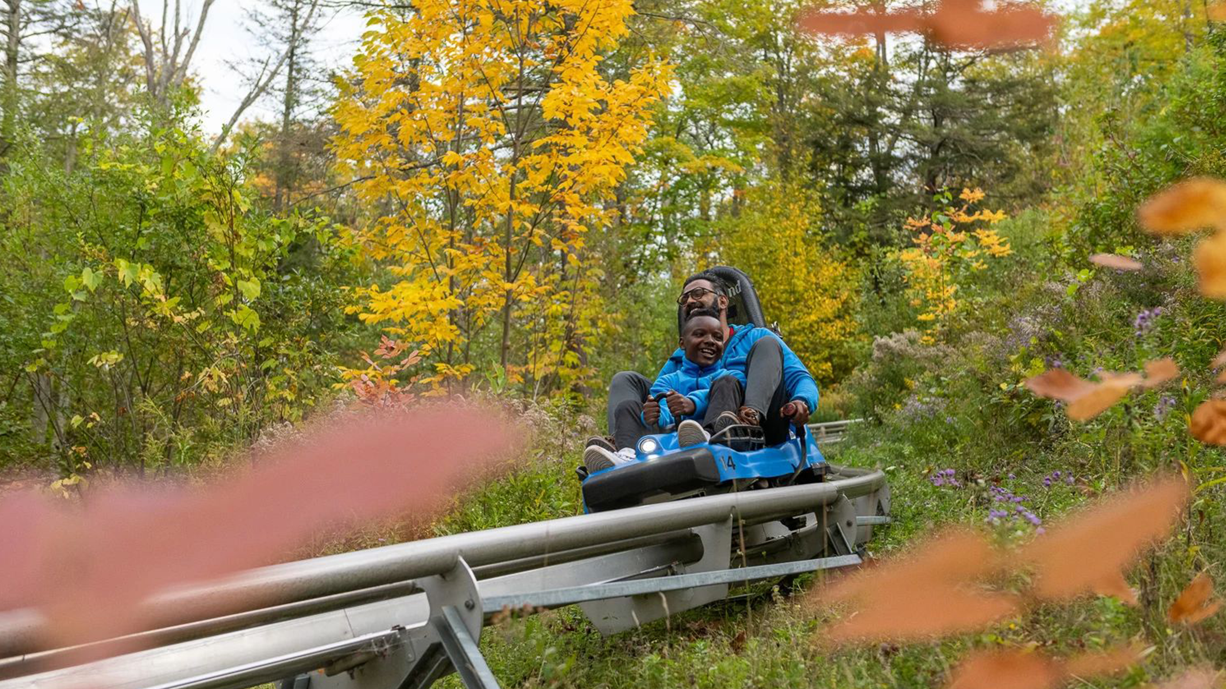 Two people riding the Ridgerunner rollercoaster at Blue Mountain