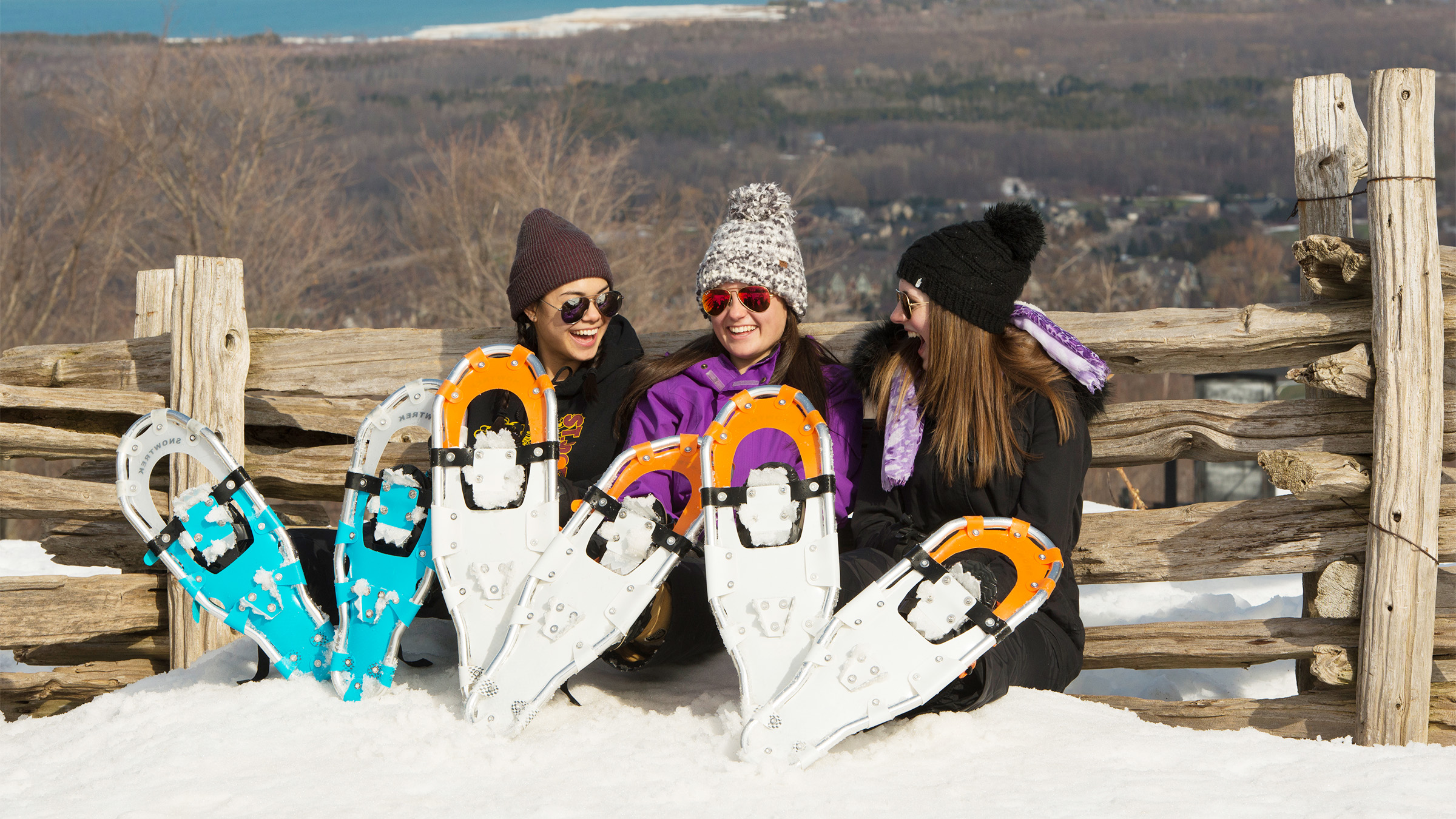 Three people sitting on top of Blue Mountain with rented snowshoes