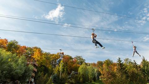 Group of people riding the zip line at Blue Mountain during the Fall