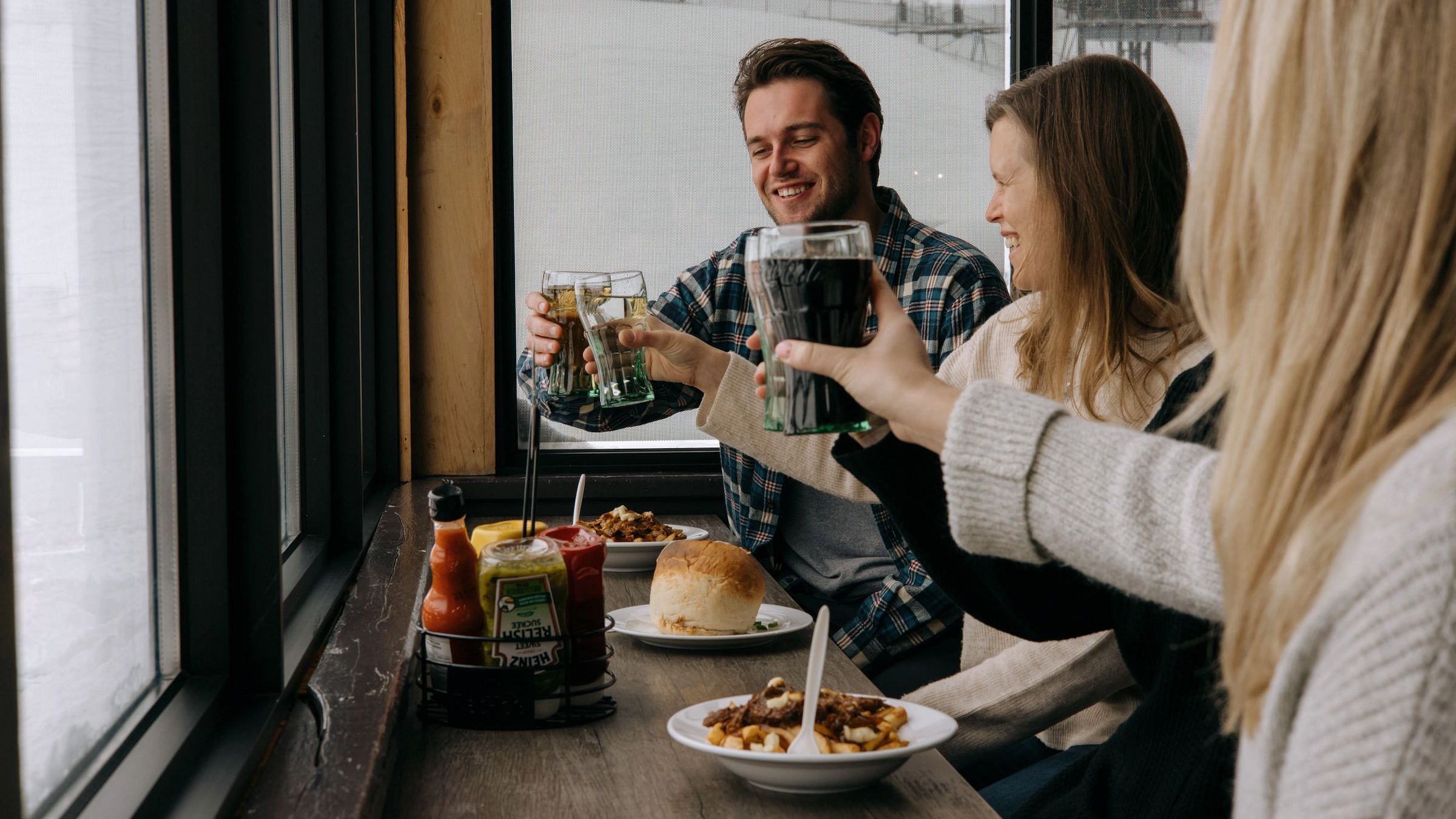Friends with food and drinks at the window at Grand Central Lodge at Blue Mountain Resort