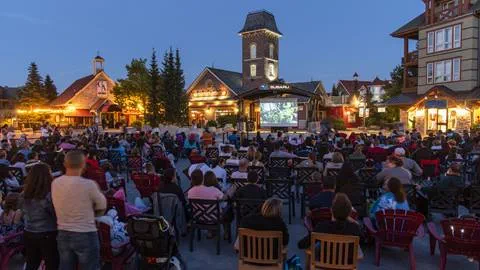 Group of people sitting outside in the Village Plaza watching movies