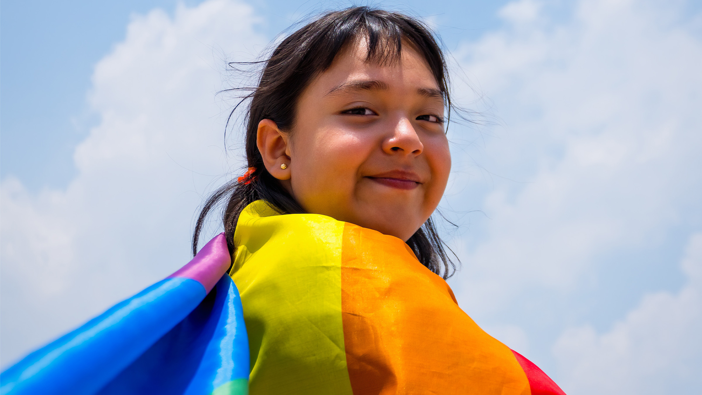 Woman holding pride flag  at Rainbow Ski Weekend at Blue Mountain