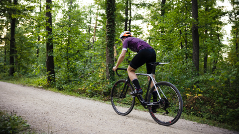 Person biking along gravel road