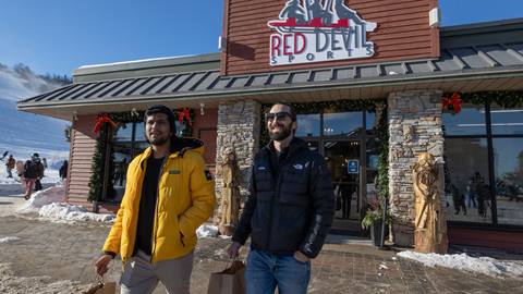 Two people shopping in the village outside Red Devil at Blue Mountain Resort