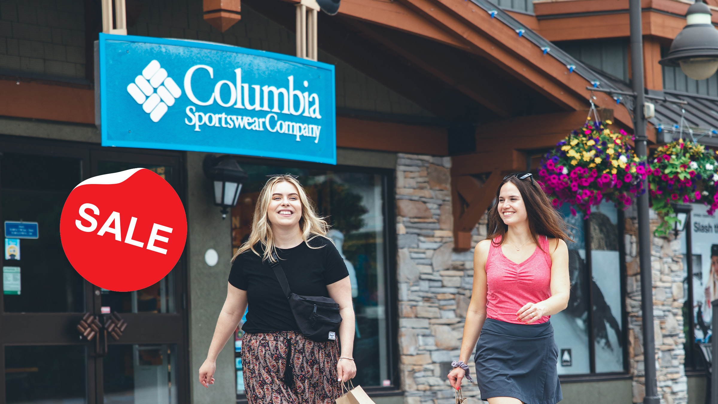 Two friends walking through Blue Mountain Village during shopping sale on long weekend