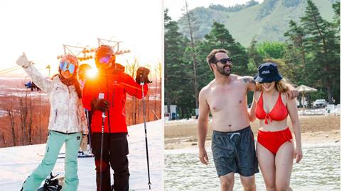 Split image: On the left, two people in winter gear pose on a snowy ski slope; on the right, a man and woman in swimsuits walk by the beach with trees and hills in the background.