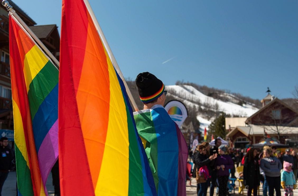 Man holding pride flag at Blue Mountain Rainbow weekend