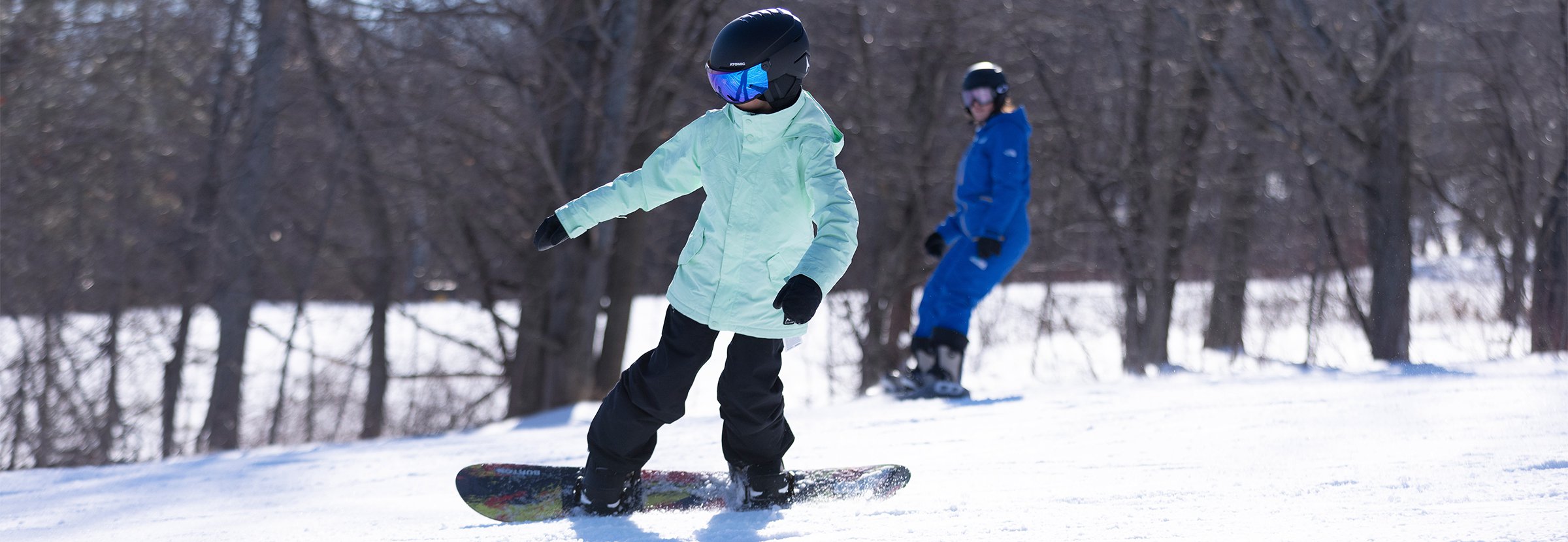 A girl participating in a private snowboard lesson