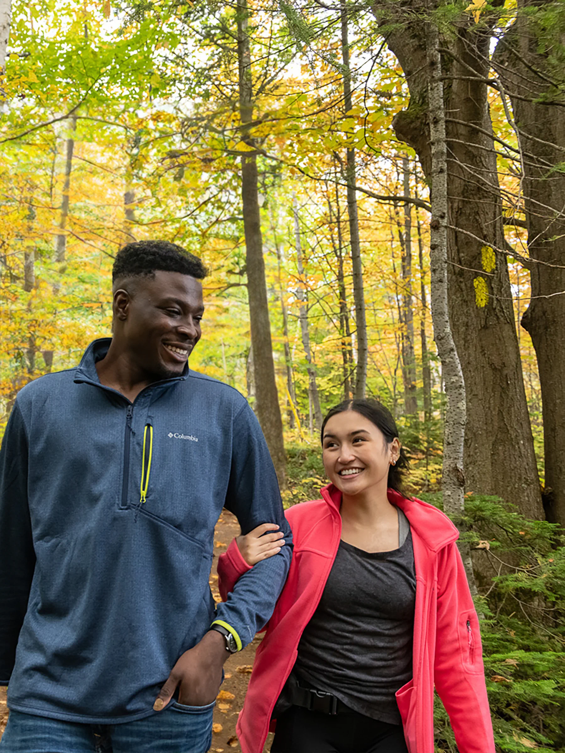 Two friends enjoying a hike in a forest during autumn.