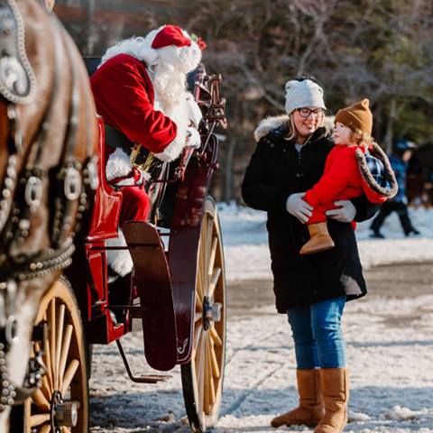 a mother and her baby greeting Santa in the Blue Mountain Village