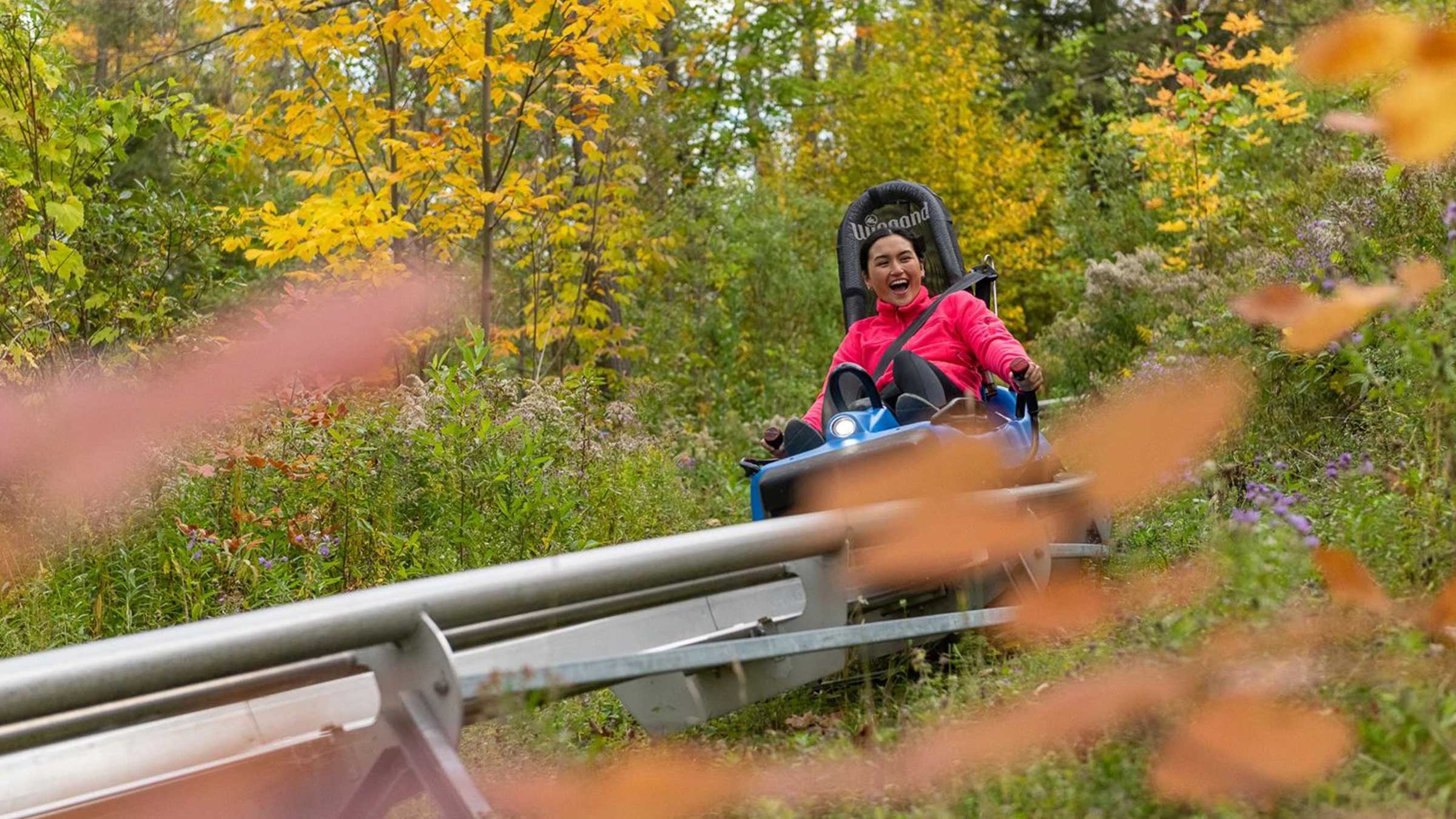 women happy on mountain coaster in autumn
