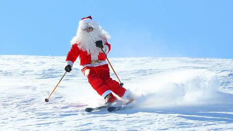 Man dressed in Santa outfit skiing