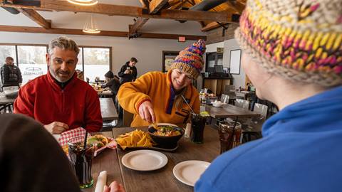 a group of people sitting at a table with a plate of food