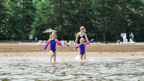 a mother and two daughters running into the water at Blue Mountain Private Beach
