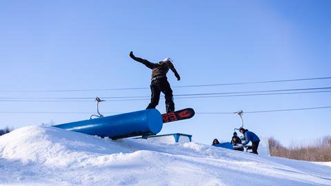a person riding a snowboard down a snow covered slope