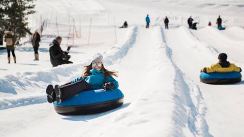 Group of young adults snow tubing