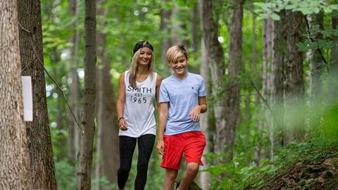 two young adults enjoying a walk on a marked hiking trail at blue mountain resort