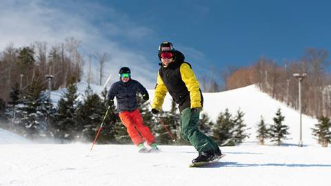 Skier and snowboarder on hill