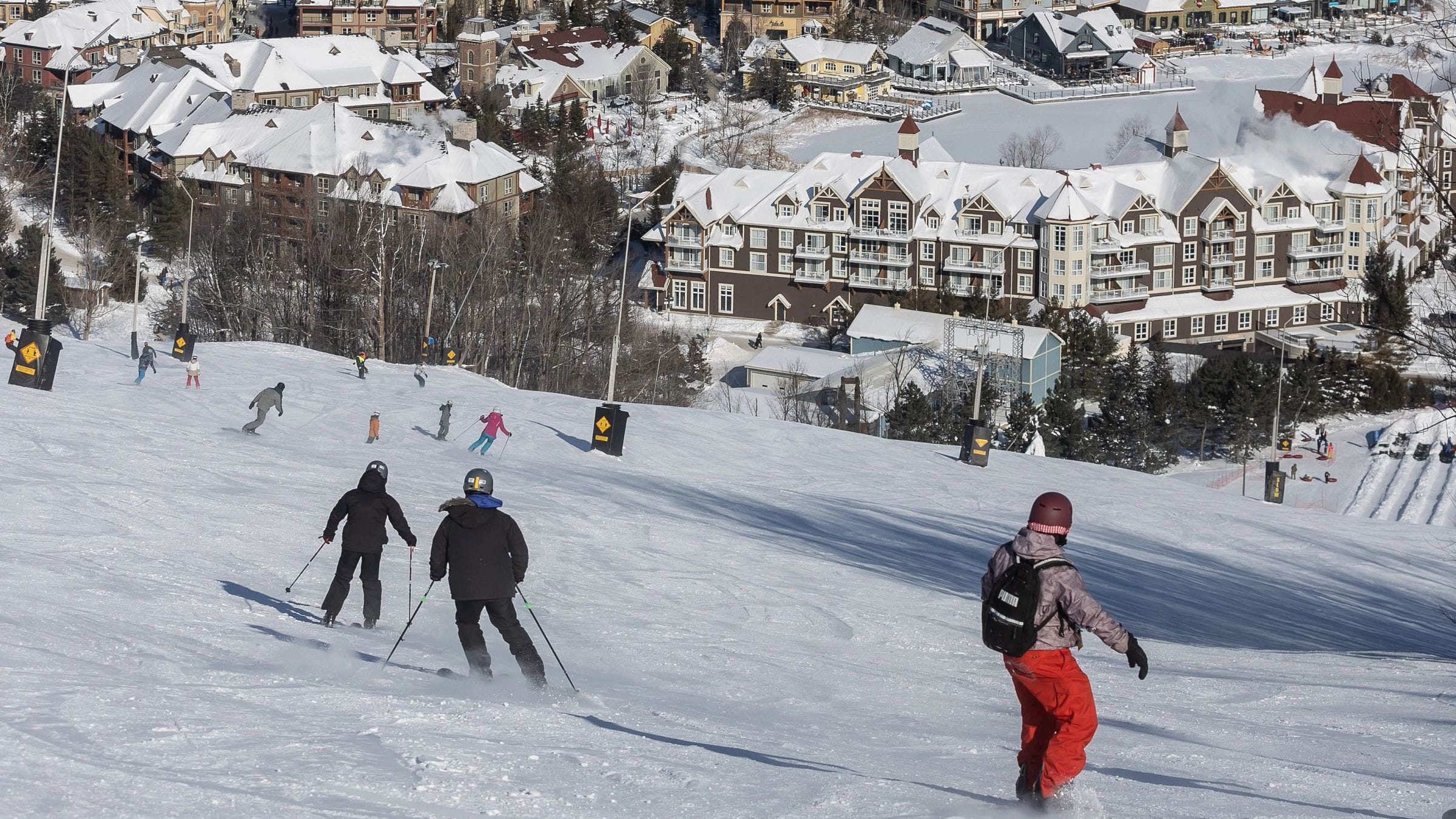 Skiers and Snowboards on Blue Mountain with Lodging in Background